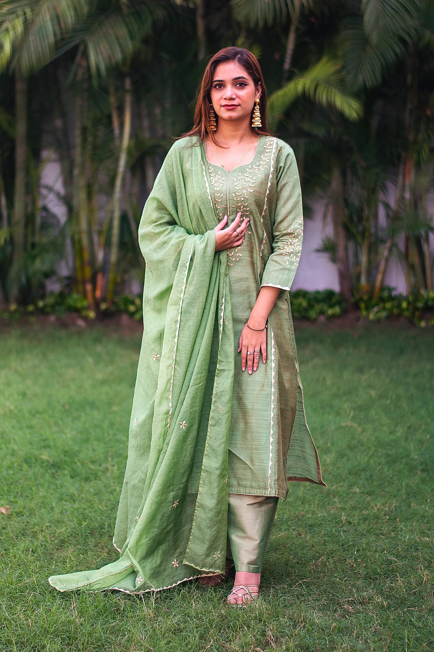 Indian model in a green jute silk kurta and chanderi dupatta with beige applique work, paired with a matching palazzo.