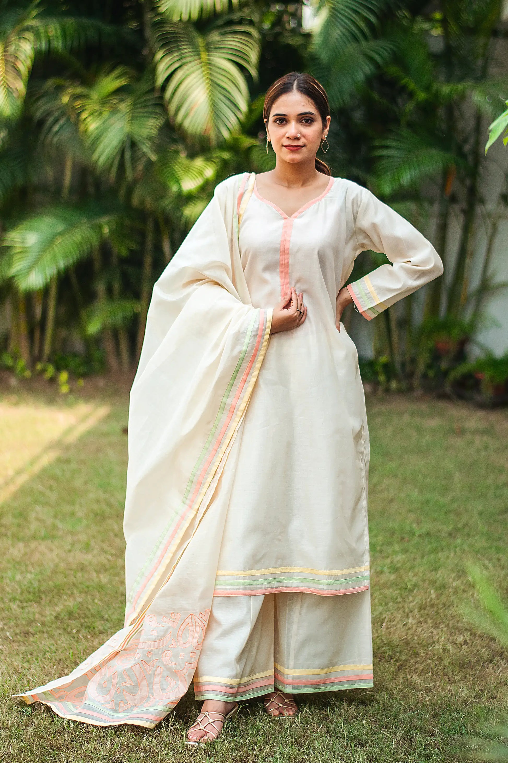 Indian model wearing an off-white chanderi kurta with pastel piping, paired with pastel patchwork dupatta and palazzo.