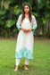 Front view of a model wearing the off-white Chanderi suit with cyan green floral cutwork, complete with off-white Chanderi kurta, cotton silk trousers