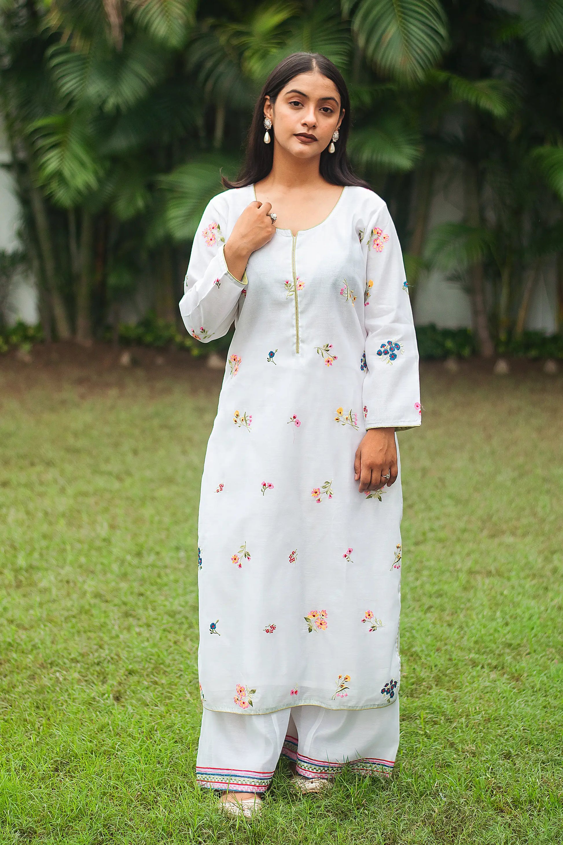 Indian model wearing a white chanderi kurta with resham embroidery, paired with white palazzo.