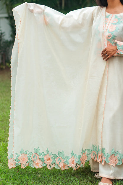 Indian model holding a cream chanderi dupatta with peach floral patchwork along the borders.