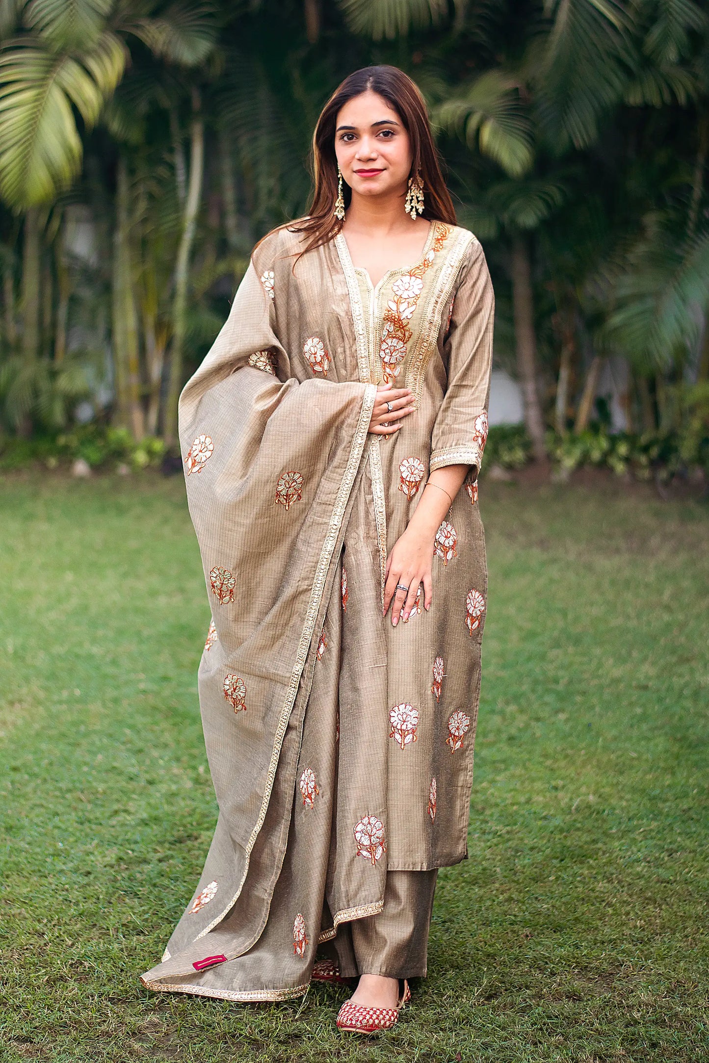 Indian model wearing a beige chanderi kurta and dupatta with golden gota patti work, paired with a beige palazzo