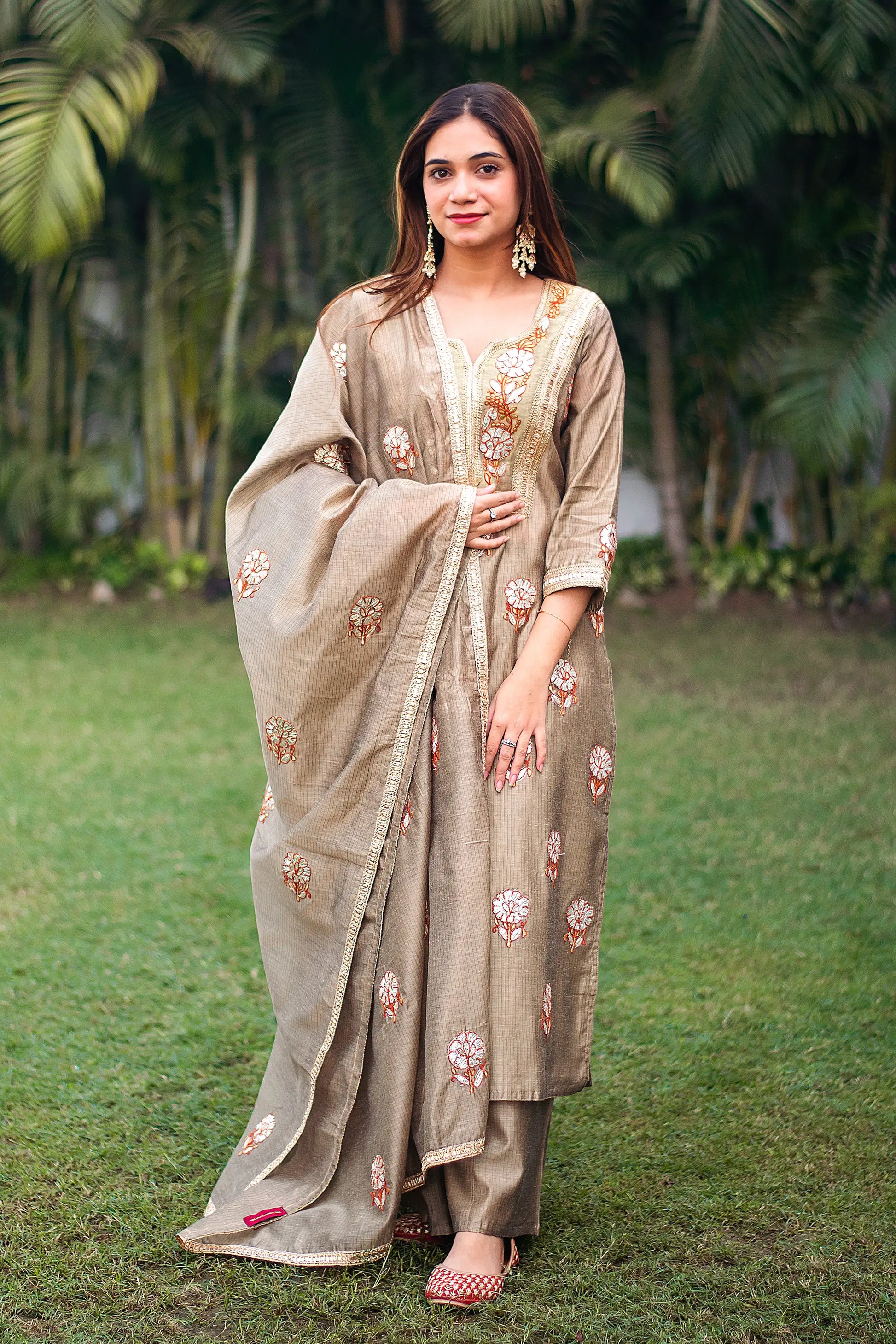 Indian model wearing a beige chanderi kurta and dupatta with golden gota patti work, paired with a beige palazzo