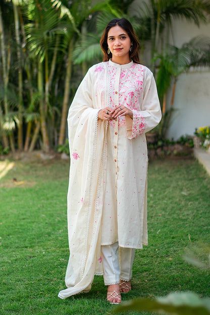 Indian woman wearing a kurti set with pink floral thread work.