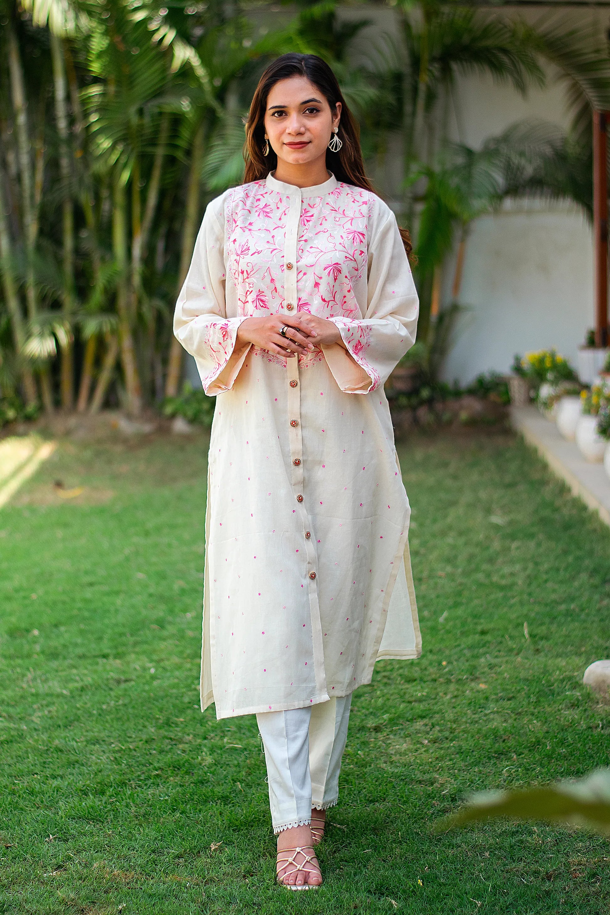 Indian model in an off-white kurti with Kashmiri work, paired with plain trousers.