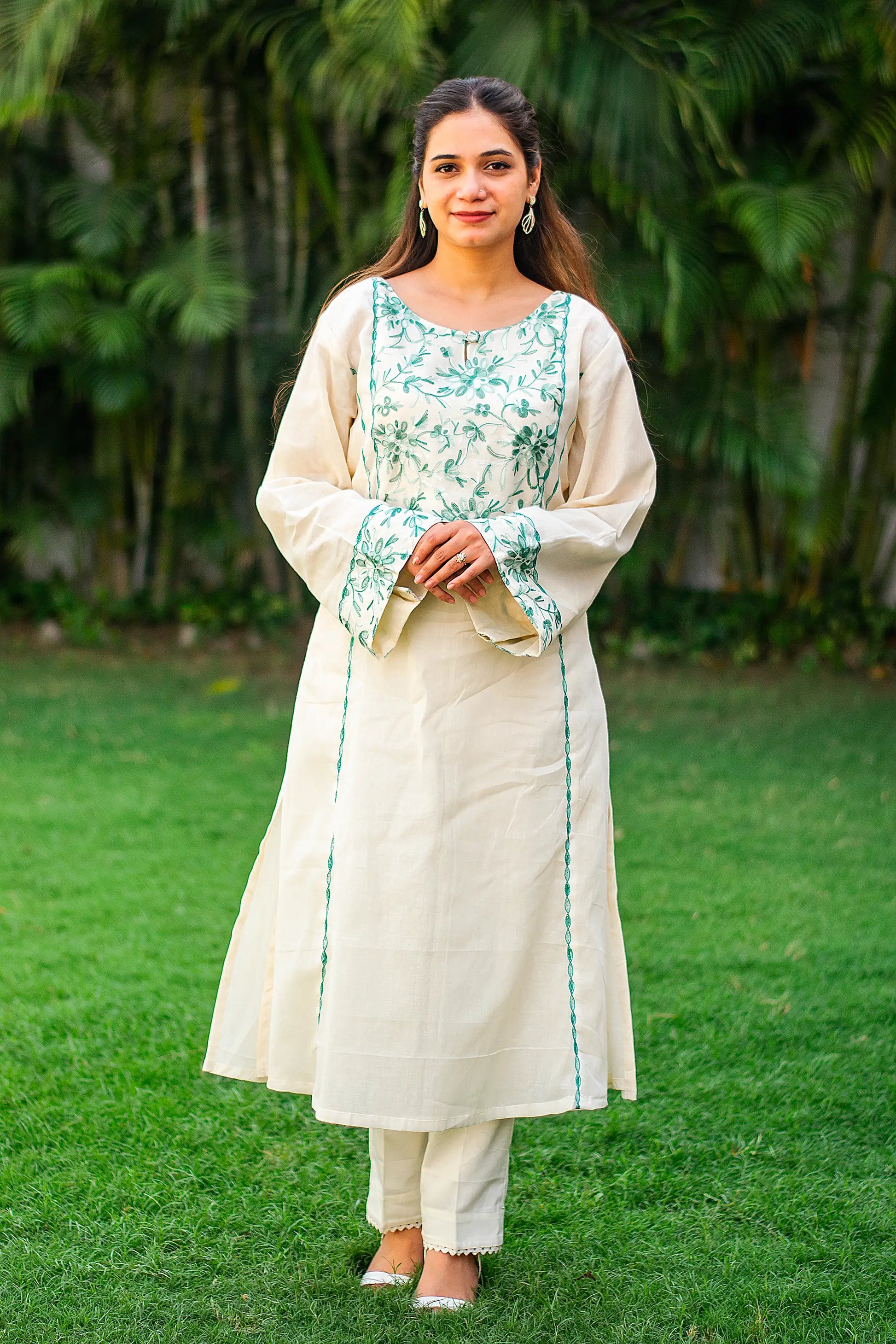 ndian model in an off-white kurti with green Kashmiri embroidery, paired with matching trousers.