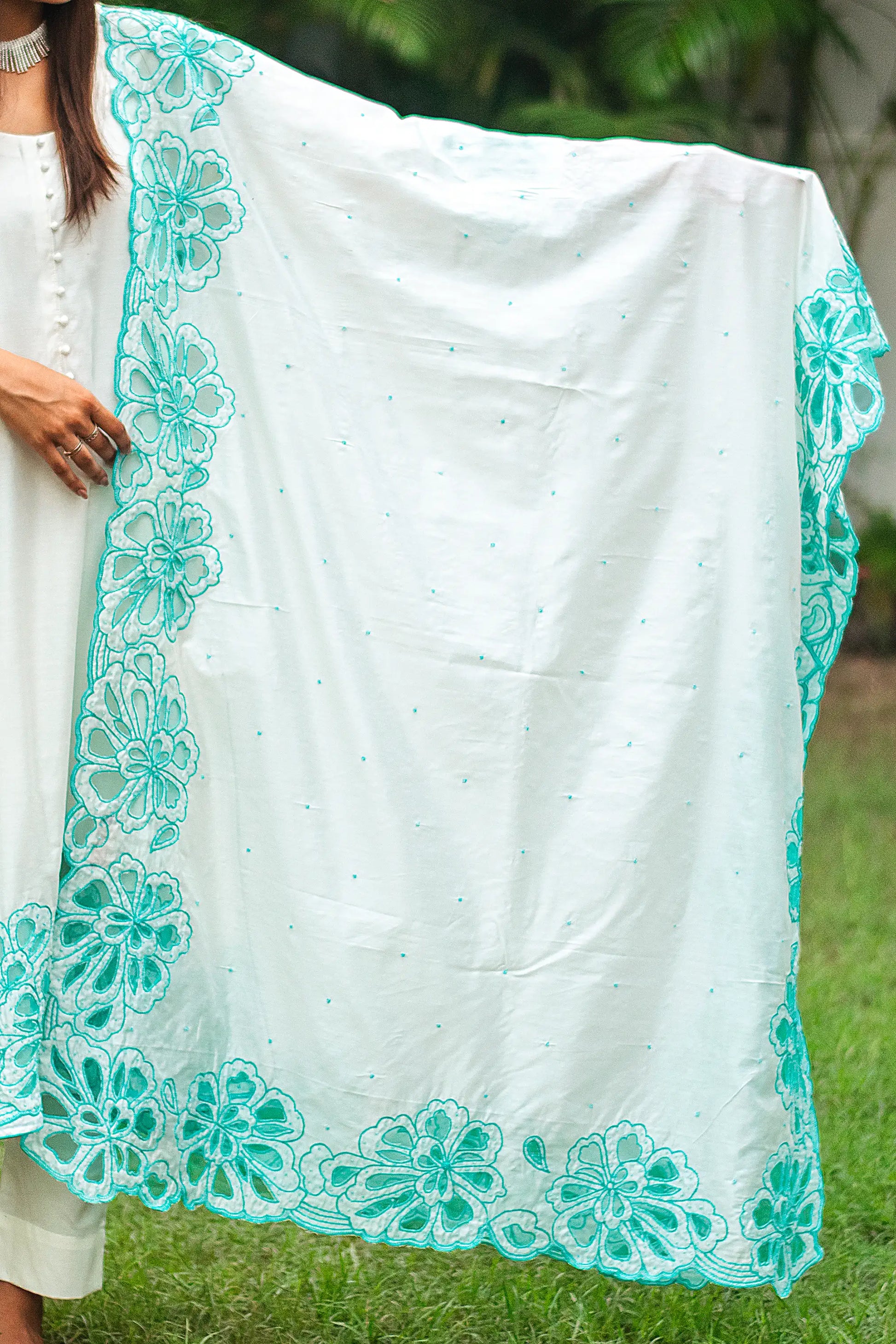 Detail of the Chanderi dupatta with cyan green cutwork flowers and sequins, as styled by the model