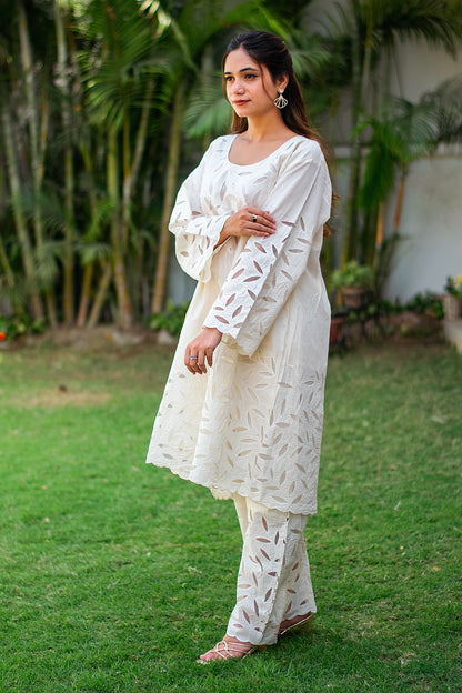 Side view of an Indian model in an off-white kurta and matching pants, showcasing floral cutwork embroidery. 