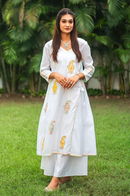 Indian model wearing a white chanderi angarkha kurta with kairi (paisley) patchwork, paired with matching white chanderi palazzo.