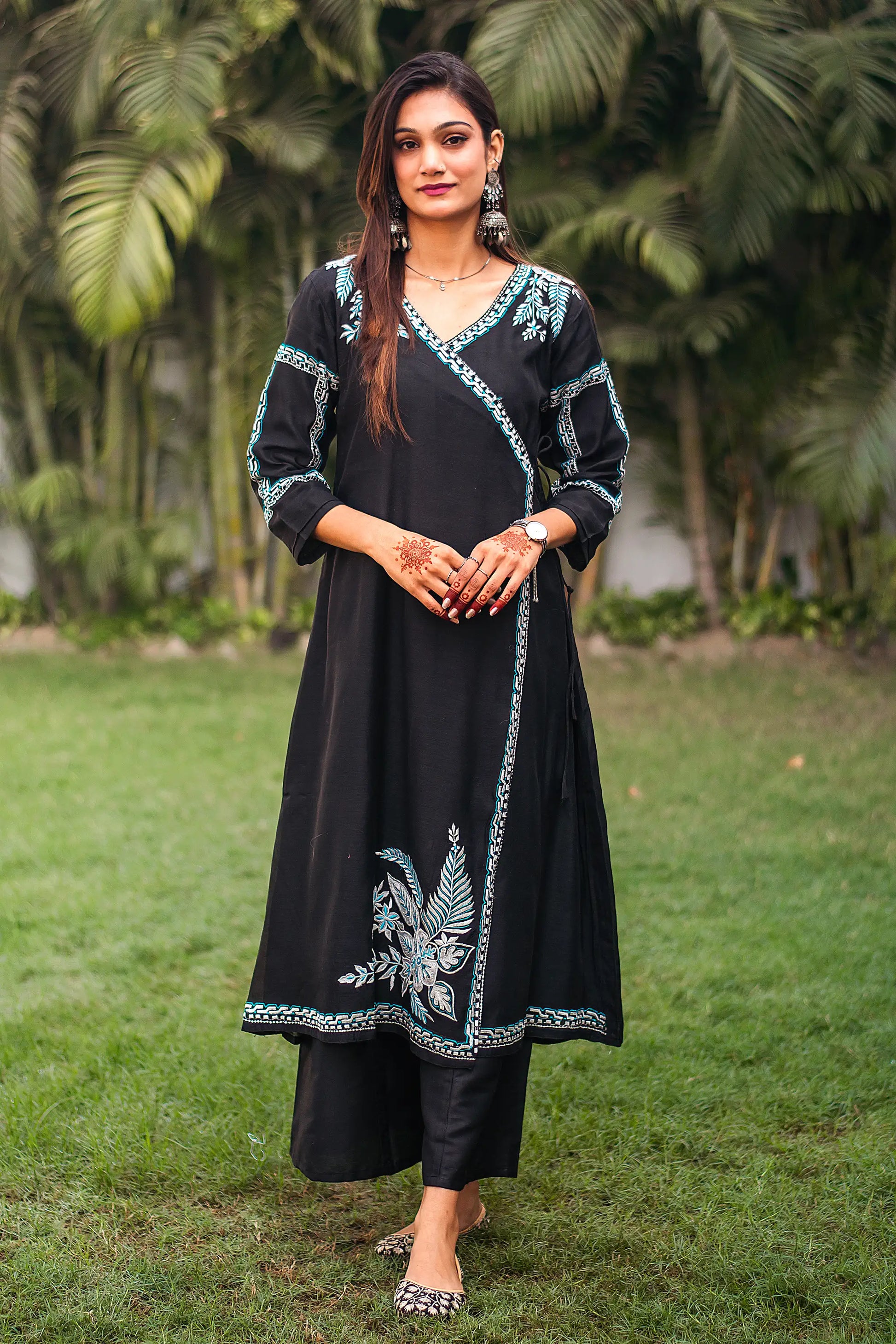 Indian model wearing a black chanderi angrakha kurta with white and blue resham embroidery, paired with black palazzo.