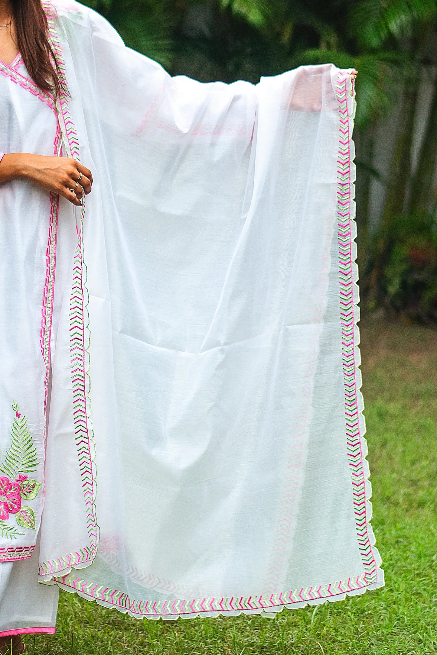 Indian model displaying the white chanderi dupatta with pink and green geometric embroidery along the borders.