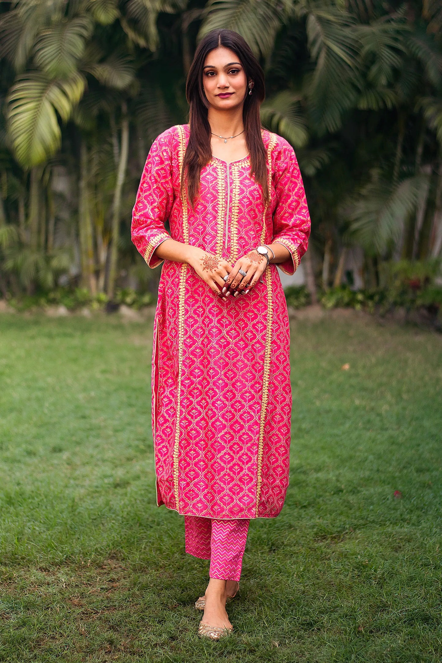 Indian model in a magenta chanderi kalidar kurta with beige applique work, paired with magenta foil-printed trousers.