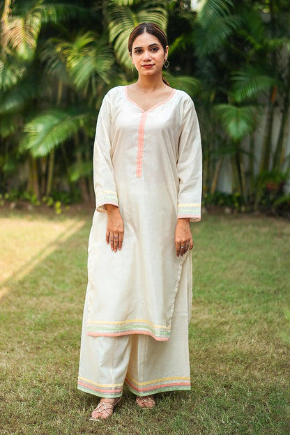 Indian model wearing an off-white chanderi kurta with pastel piping and matching off-white palazzo.