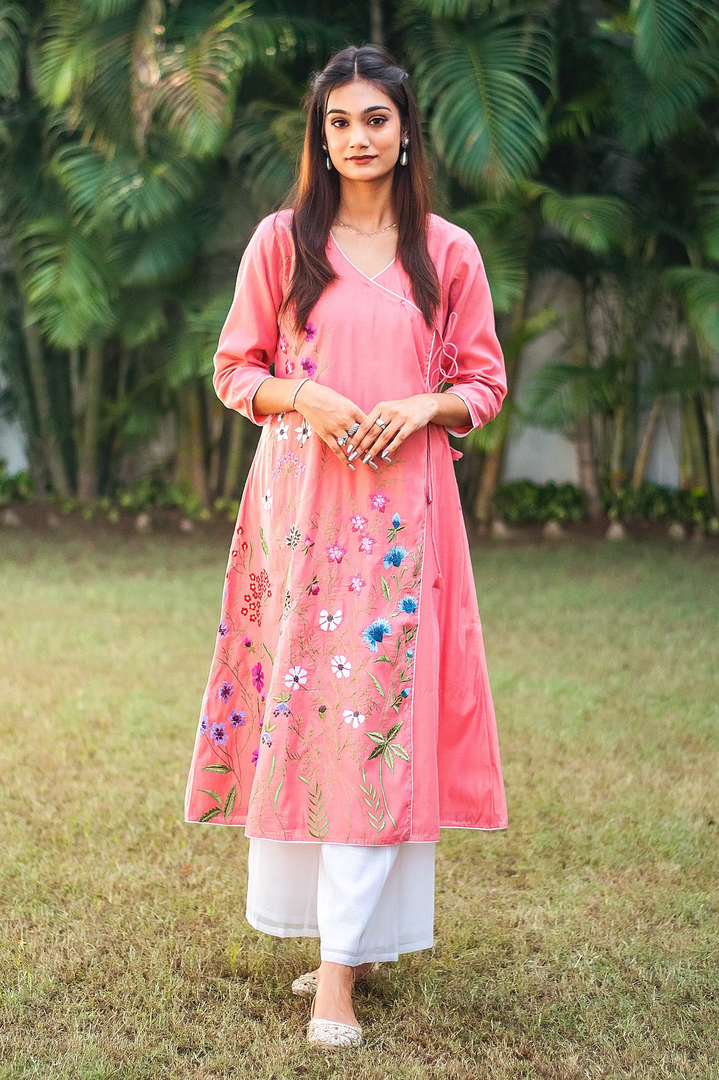 Front view of a model wearing the pink chanderi kurta set, featuring pink chanderi angarkha with multicolour floral embroidery and white palazzo.