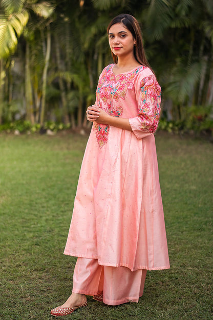 Side view of an Indian model in a peach Chanderi kurta with resham embroidery, complemented by matching peach palazzo.