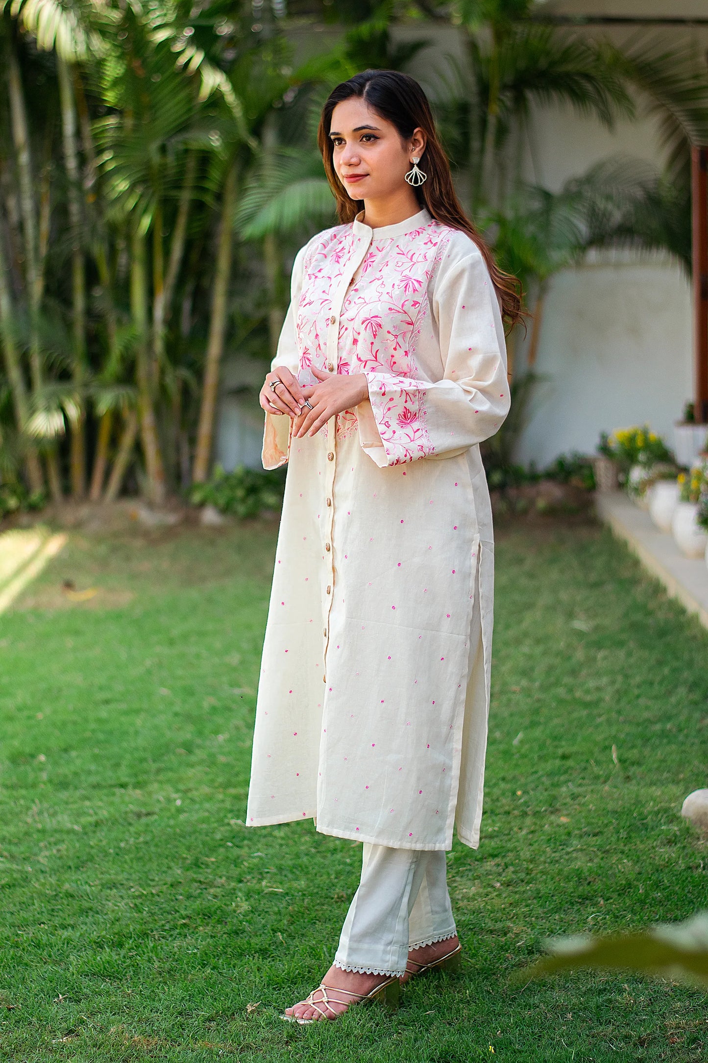 Side view of an Indian model in a front-open kurta with Kashmiri work and off-white trousers. 