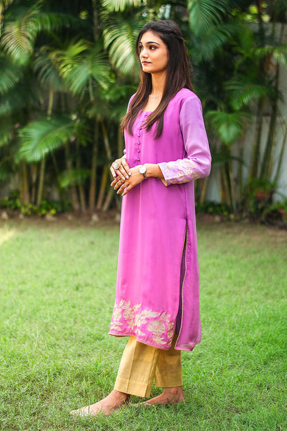 Side view of an Indian model in a light purple organza kurta, highlighting the golden floral cutwork along the hem, paired with gold trousers.