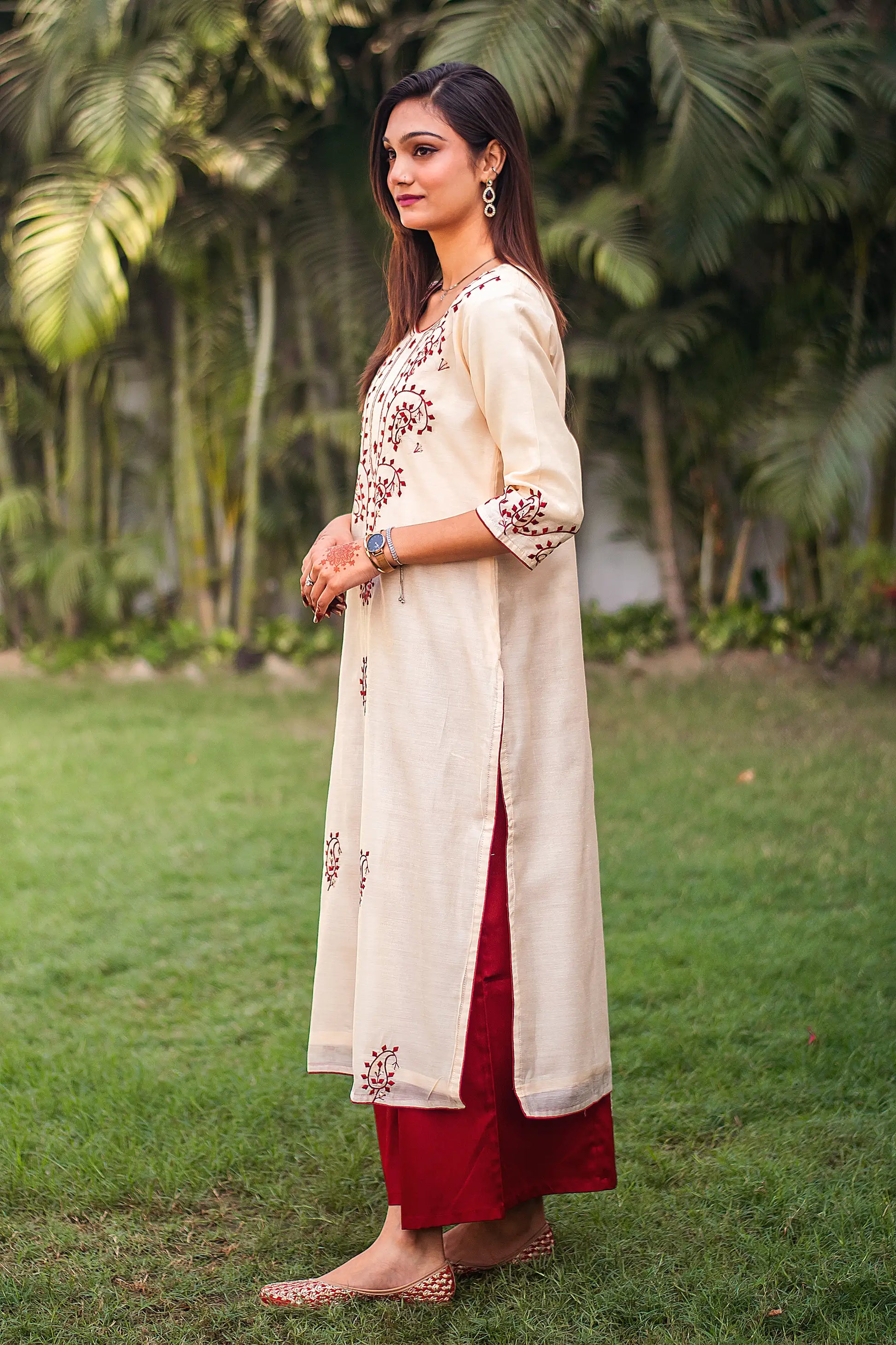 ide view of an Indian model in a beige chanderi kurta with maroon applique work, complemented by maroon palazzo.