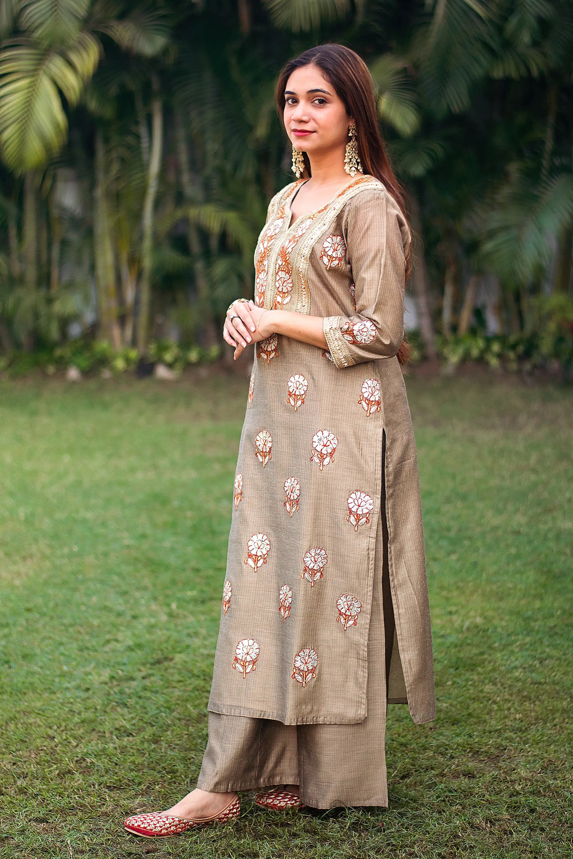 Side view of an Indian model wearing a beige Chanderi kurta with golden gota patti work and beige palazzo. 