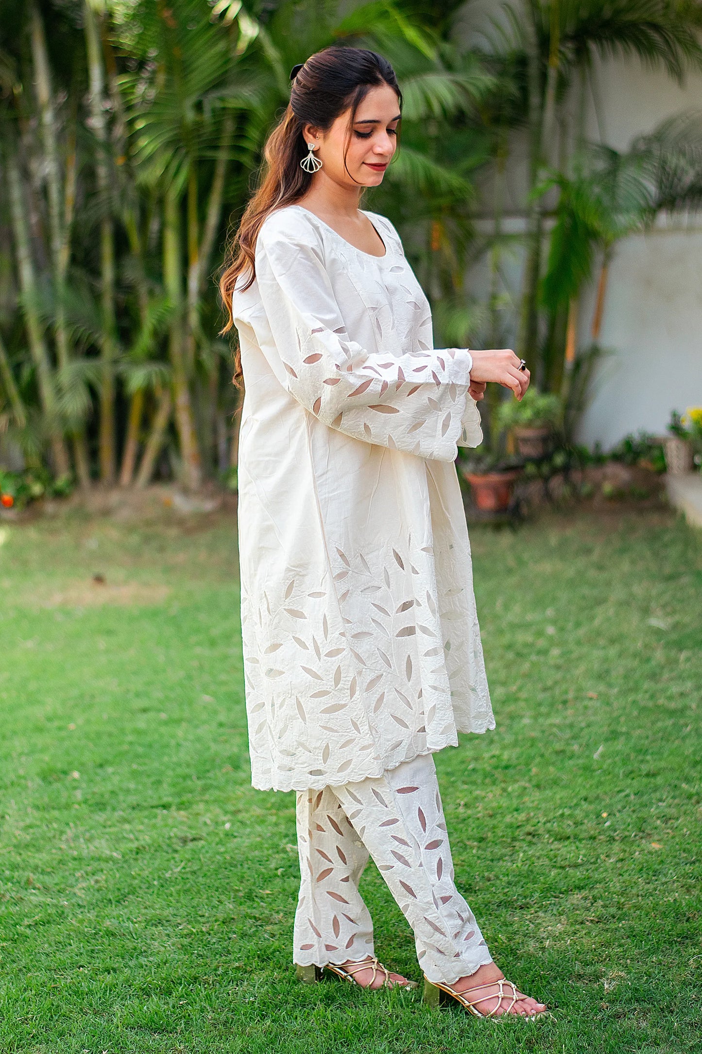 Indian woman in a side profile, highlighting the embroidery on the kurta and trousers.