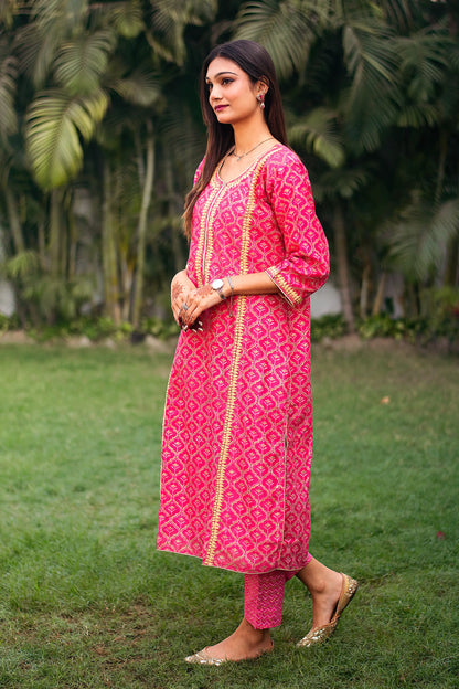 Side view of an Indian model in a magenta foil-printed chanderi kurta with beige applique work, complemented by matching magenta trousers.