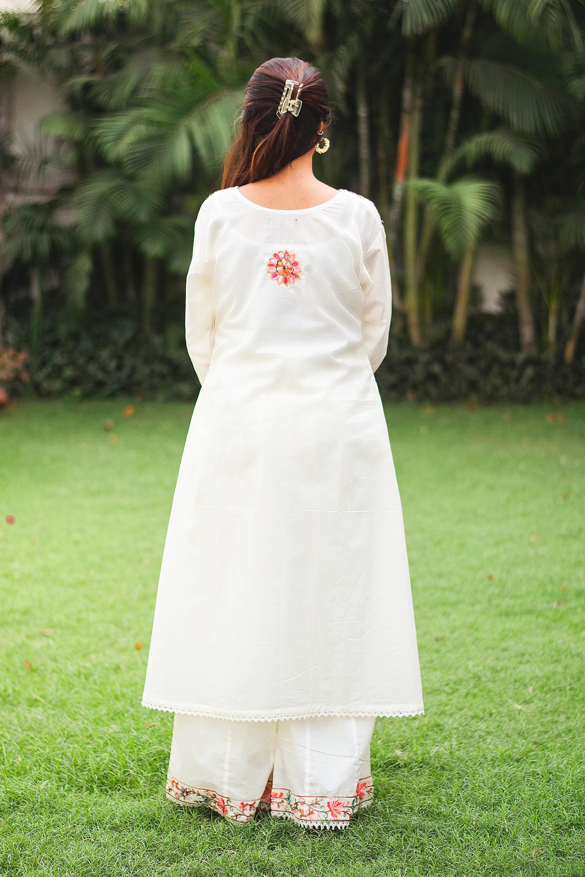 An Indian girl back pose in off-white colored Angarkha top