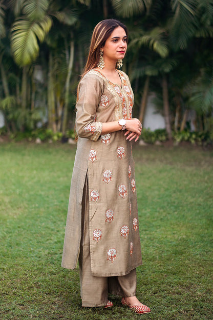 Side pose of an Indian model dressed in a beige Chanderi kurta with gota patti details and matching beige palazzo.