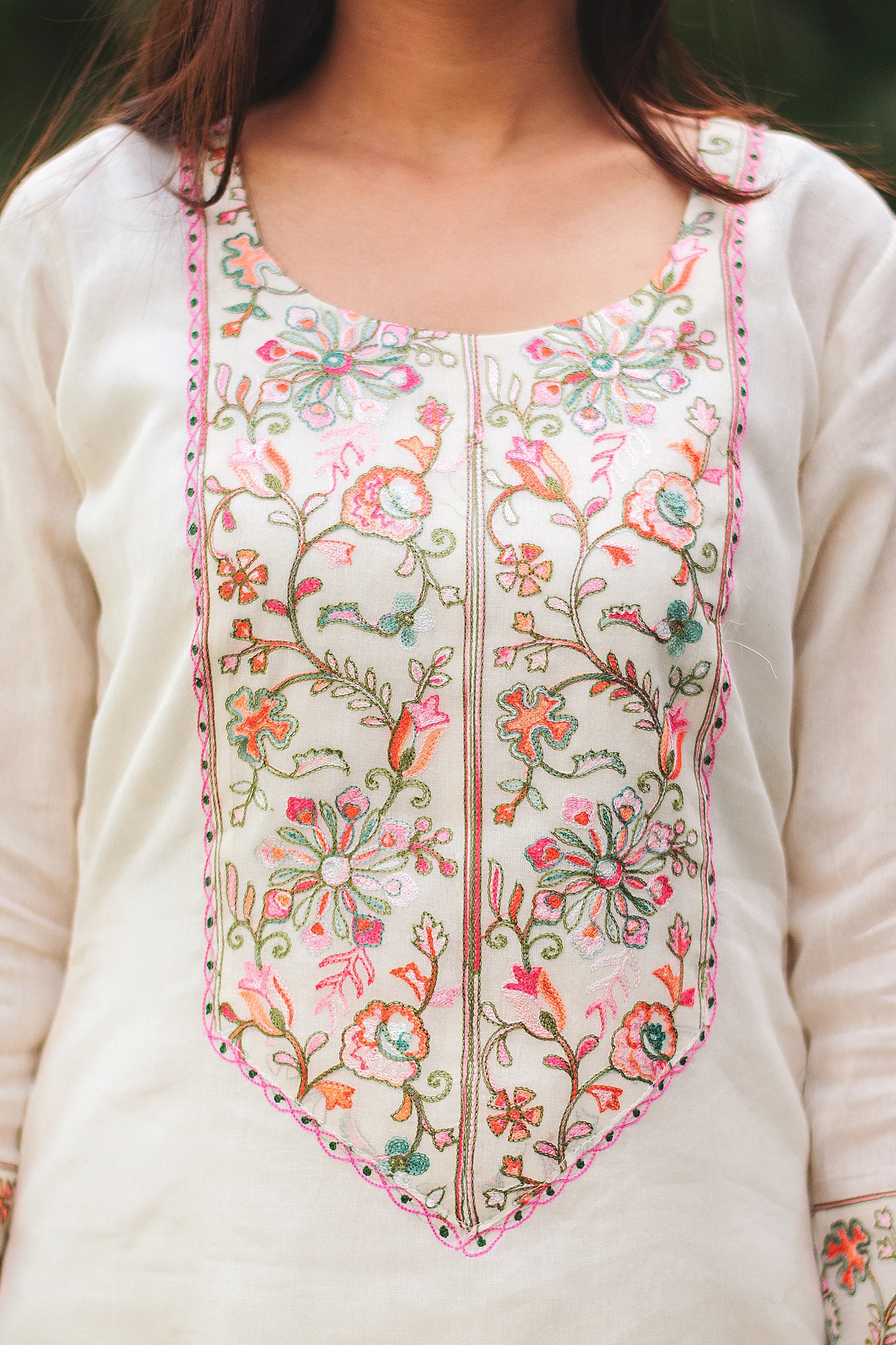 Close-up of Kashmiri embroidery on the yoke of an off-white kurta, highlighting the intricate design