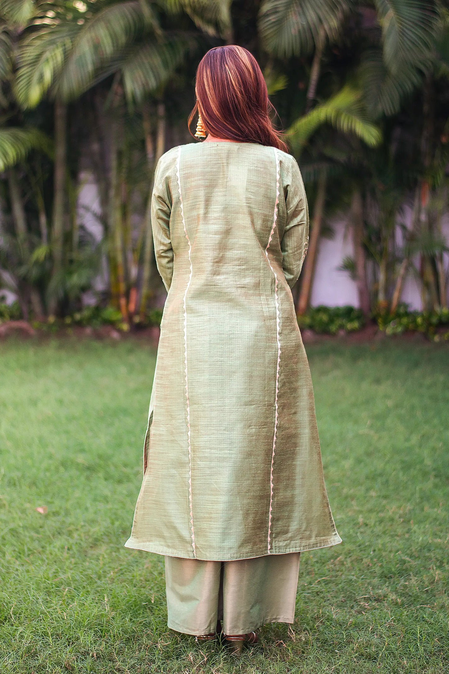 Back view of an Indian model wearing a green jute silk kurta.