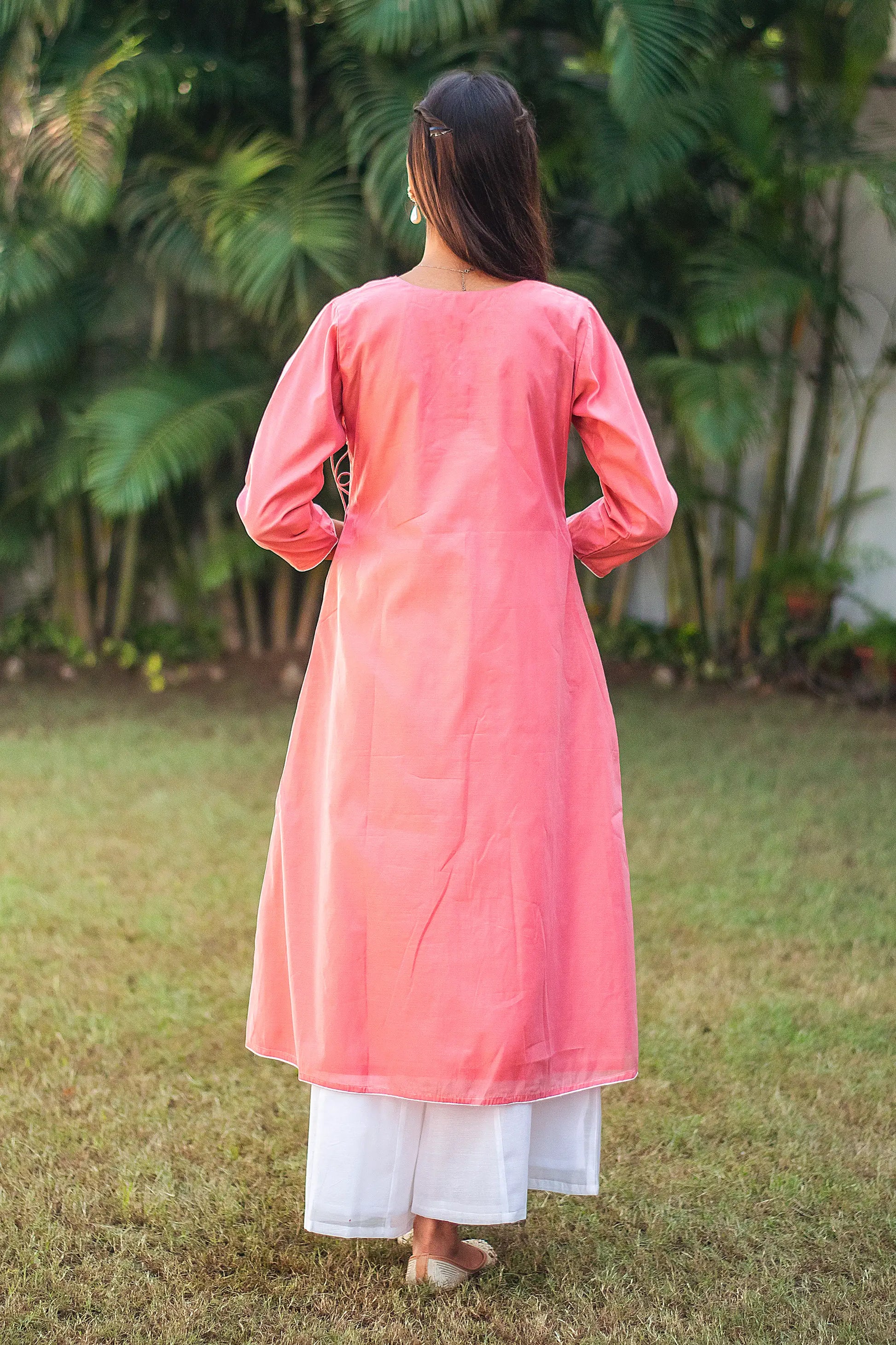 Back view of a model wearing the pink chanderi kurta set showcasing the backside of the pink angarkha and white palazzo.