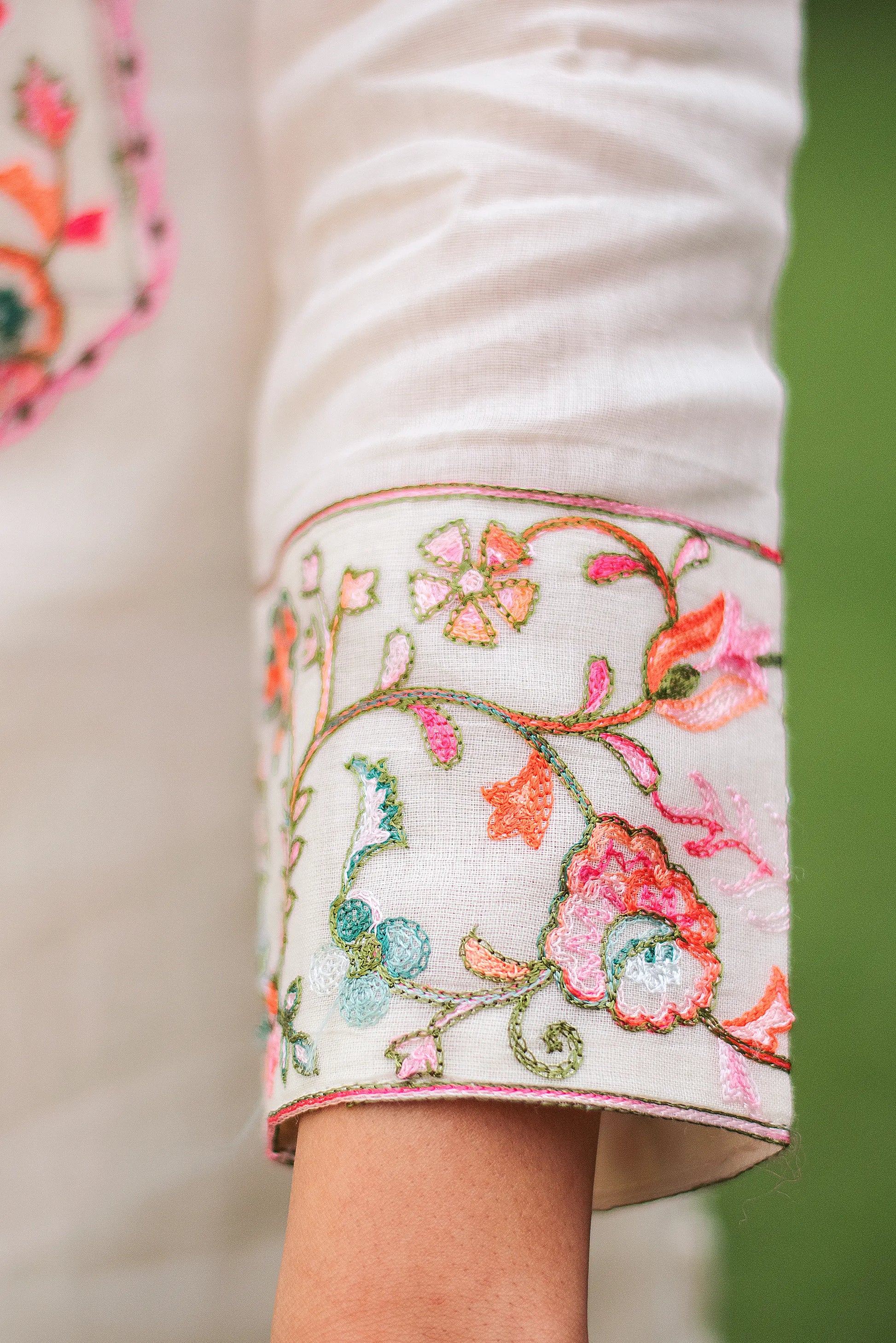 Close-up of Kashmiri embroidery on the sleeve of an off-white kurta, focusing on the details