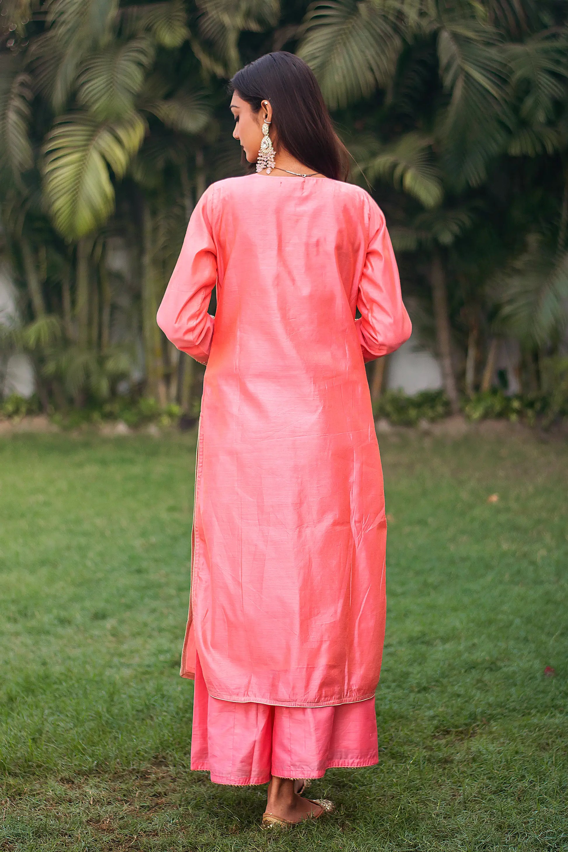 Back view of an Indian model wearing a peach chanderi kurta with zardozi work, paired with a matching peach palazzo.