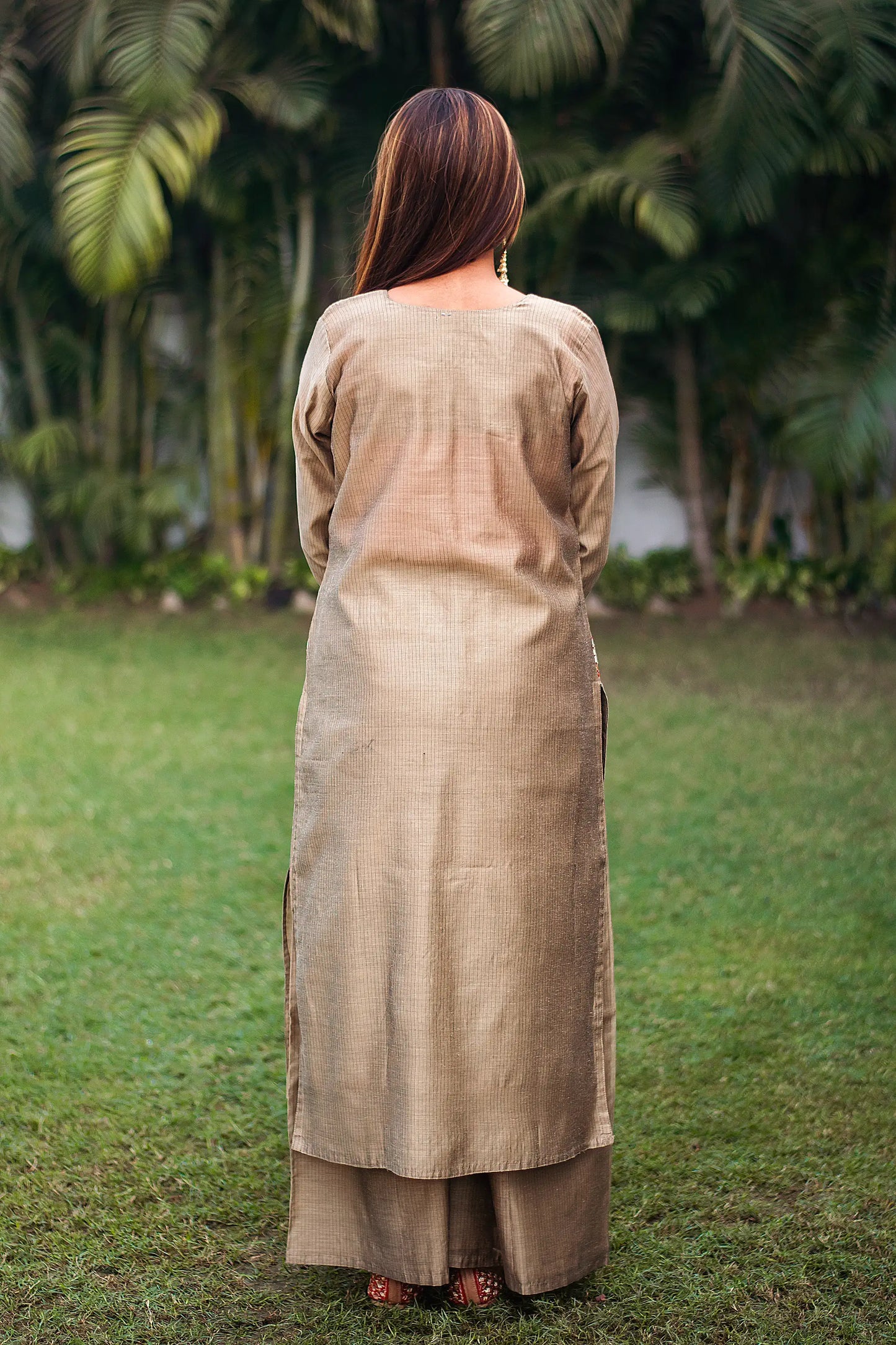 Indian model in a beige Chanderi kurta with golden gota patti work, showing the back of the kurta and beige palazzo.