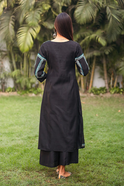 Back view of an Indian model wearing a black chanderi angrakha kurta.