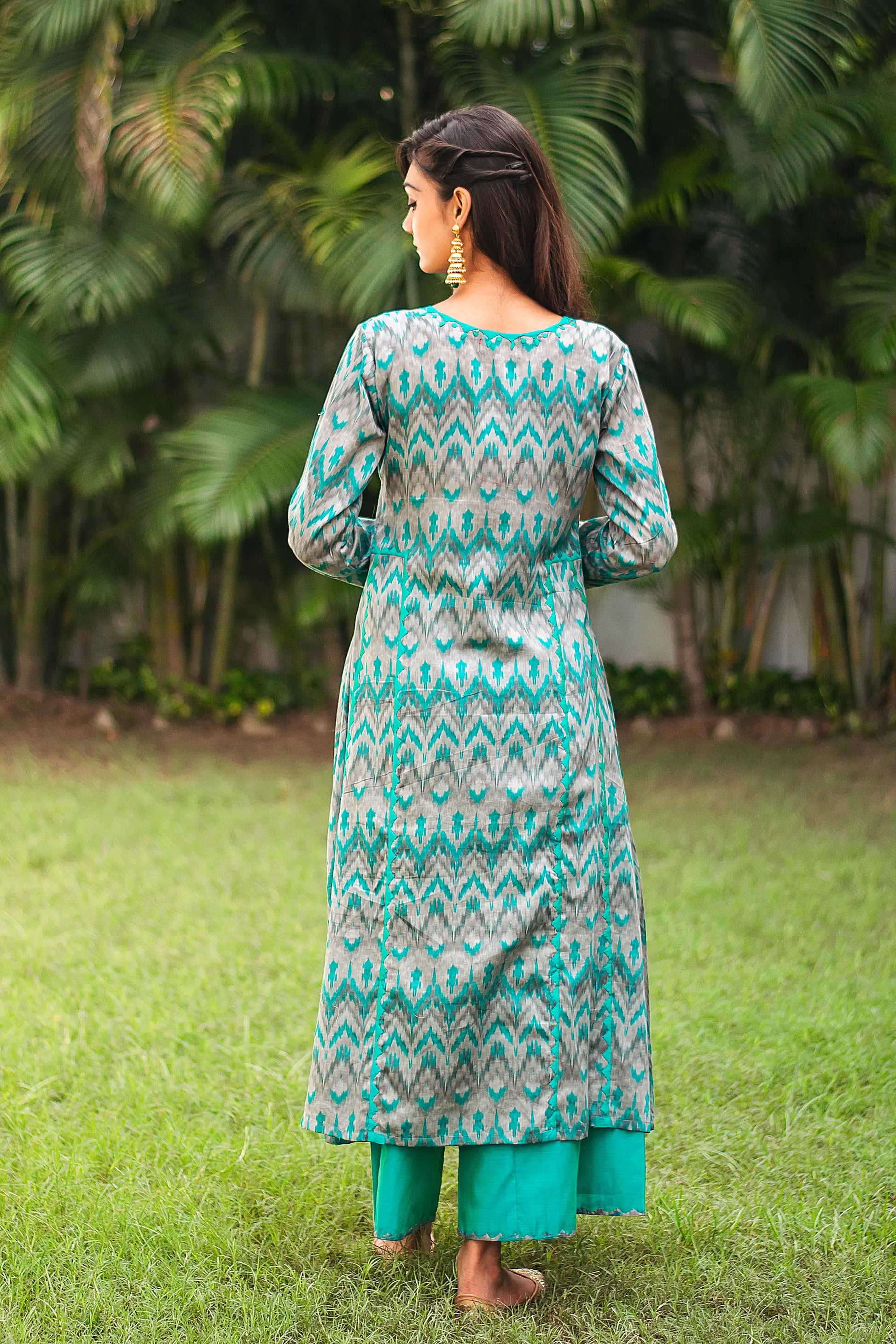 Back view of an Indian model wearing a green and grey ikat print kurta.