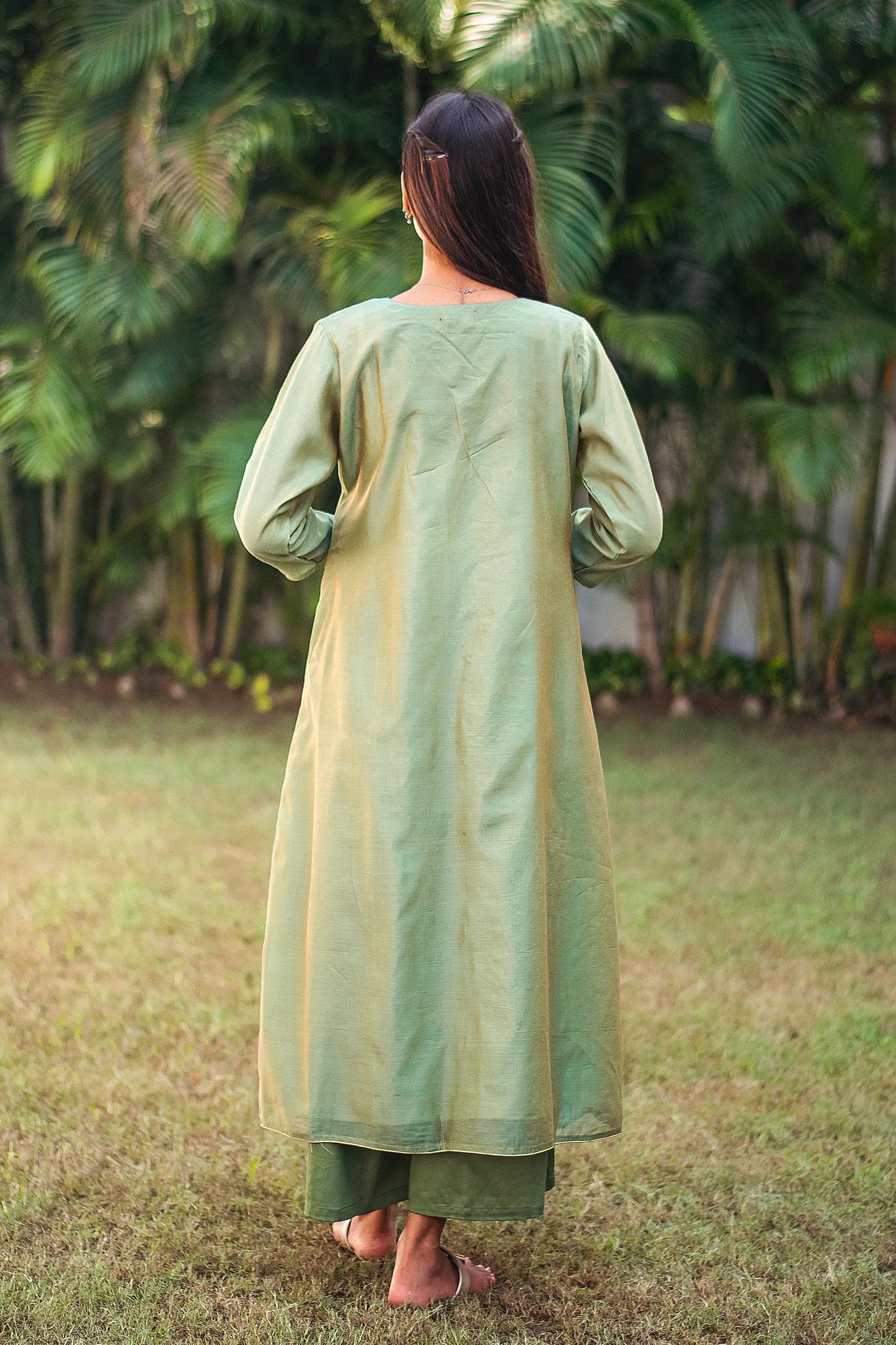 Back view of a model wearing the green kurta set showcasing the backside of the green angarkha and palazzo.