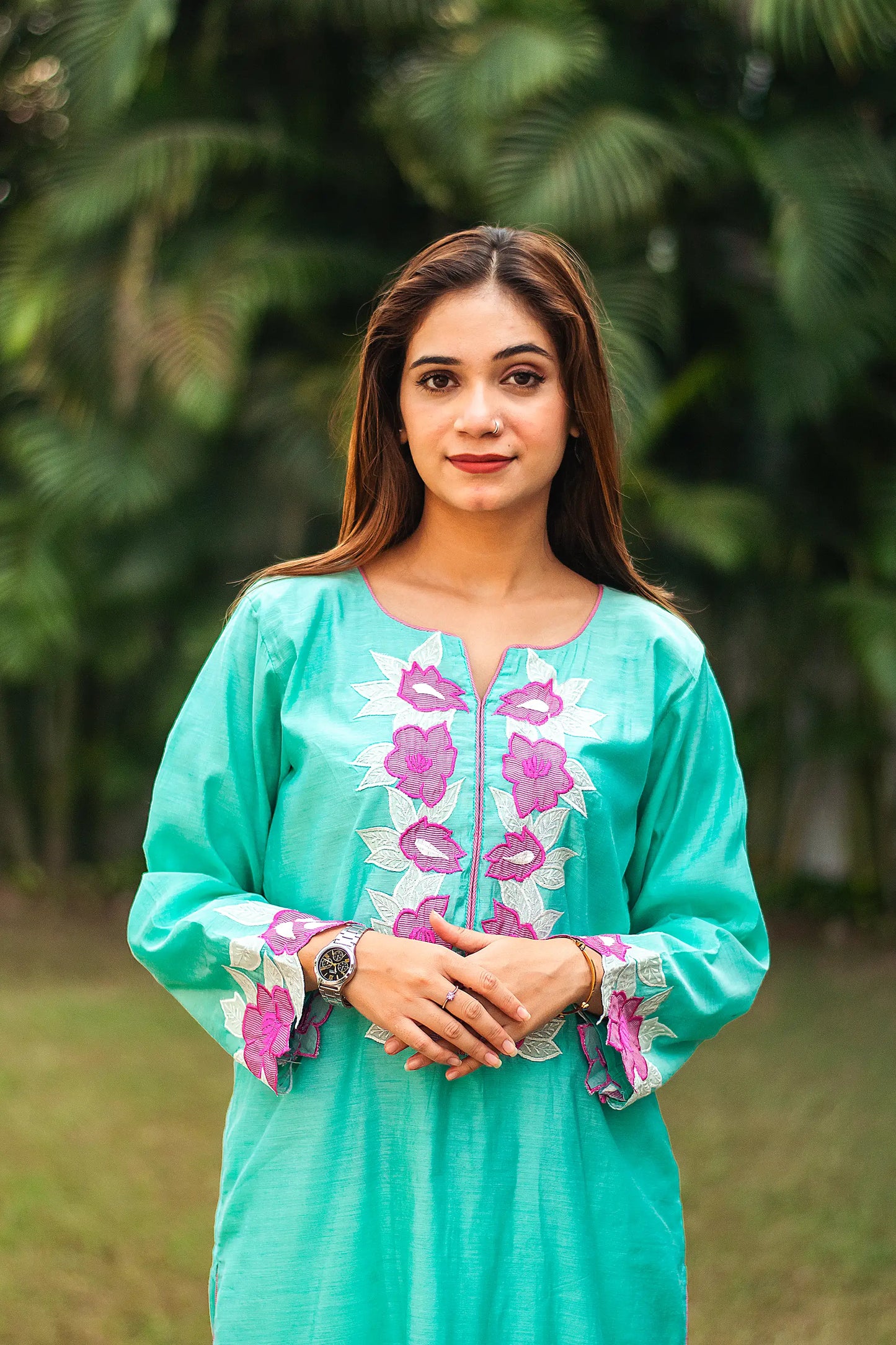 Detailed view of the purple patchwork flowers on the yoke of a blue chanderi kurta, worn by an Indian model.