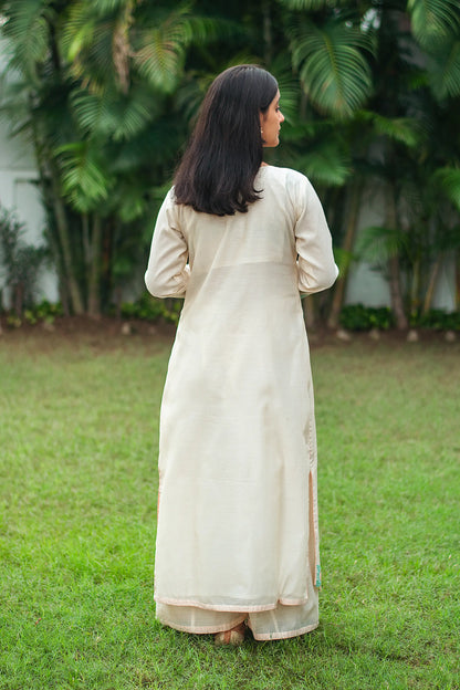 Back view of an Indian model in a cream chanderi kurta, paired with cream palazzo.