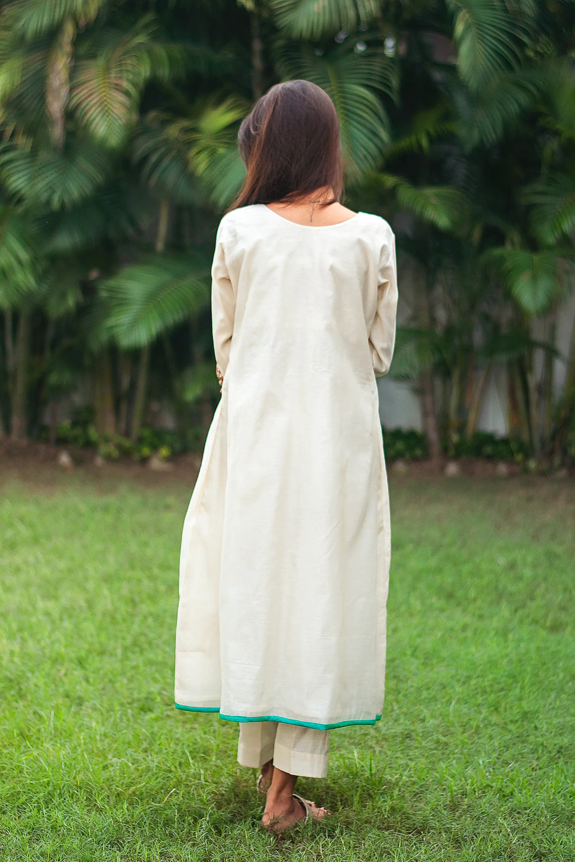 Back view of a model wearing the beige chanderi angrakha set, showcasing the full ensemble