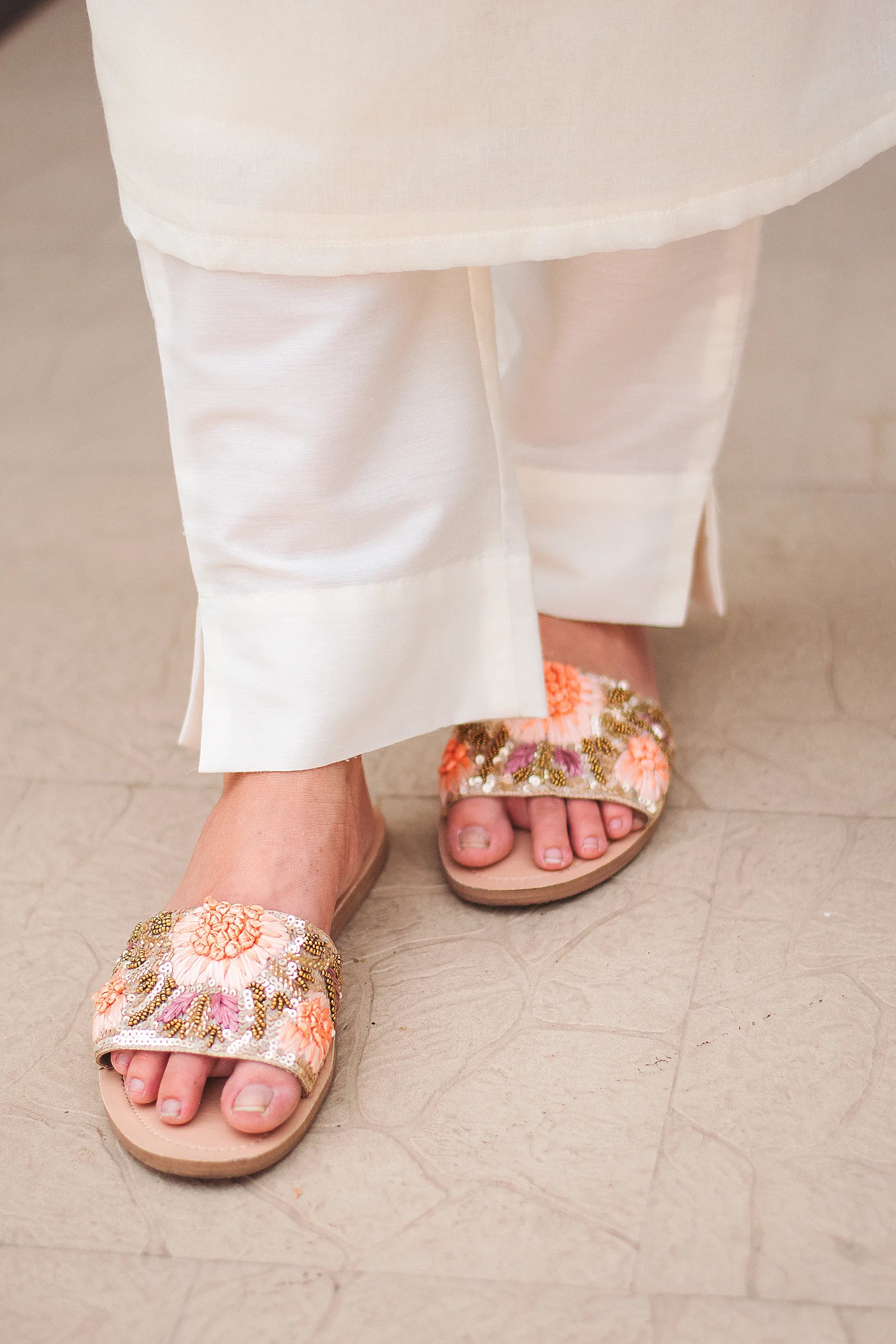 Close-up of off-white trousers, highlighting the simple and clean design