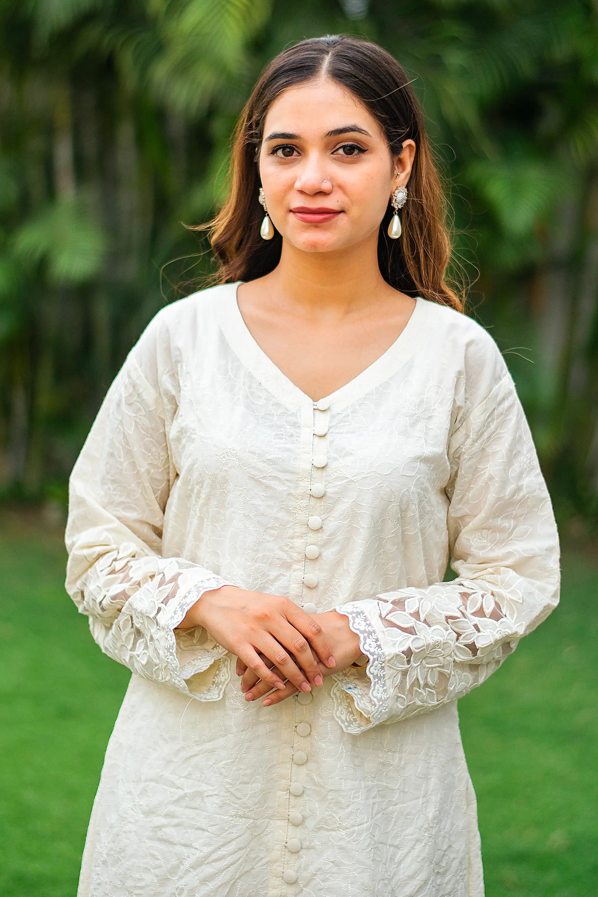 Close-up of an Indian model, focusing on the floral embroidery on the white kurta.