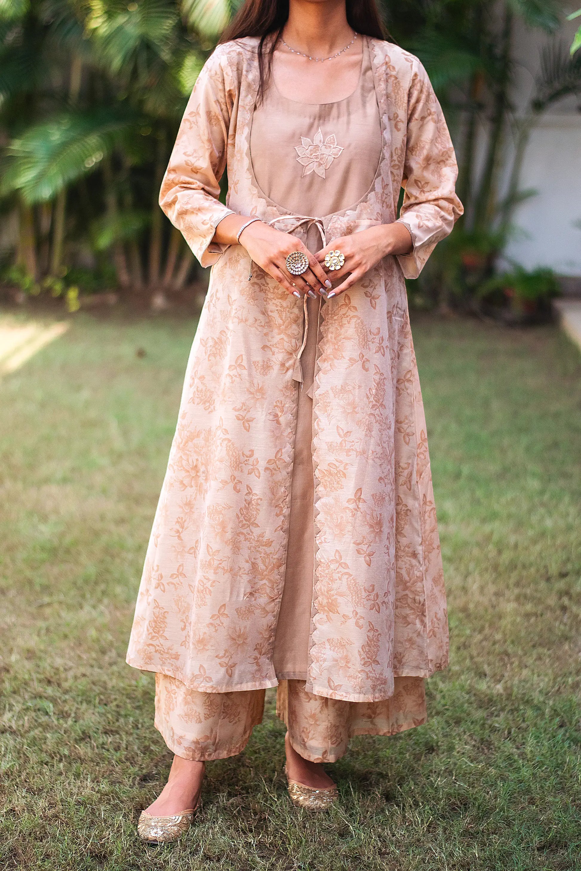 Close-up of the beige floral print chanderi fabric and intricate kikri work on the angrakha kurta, as worn by the model