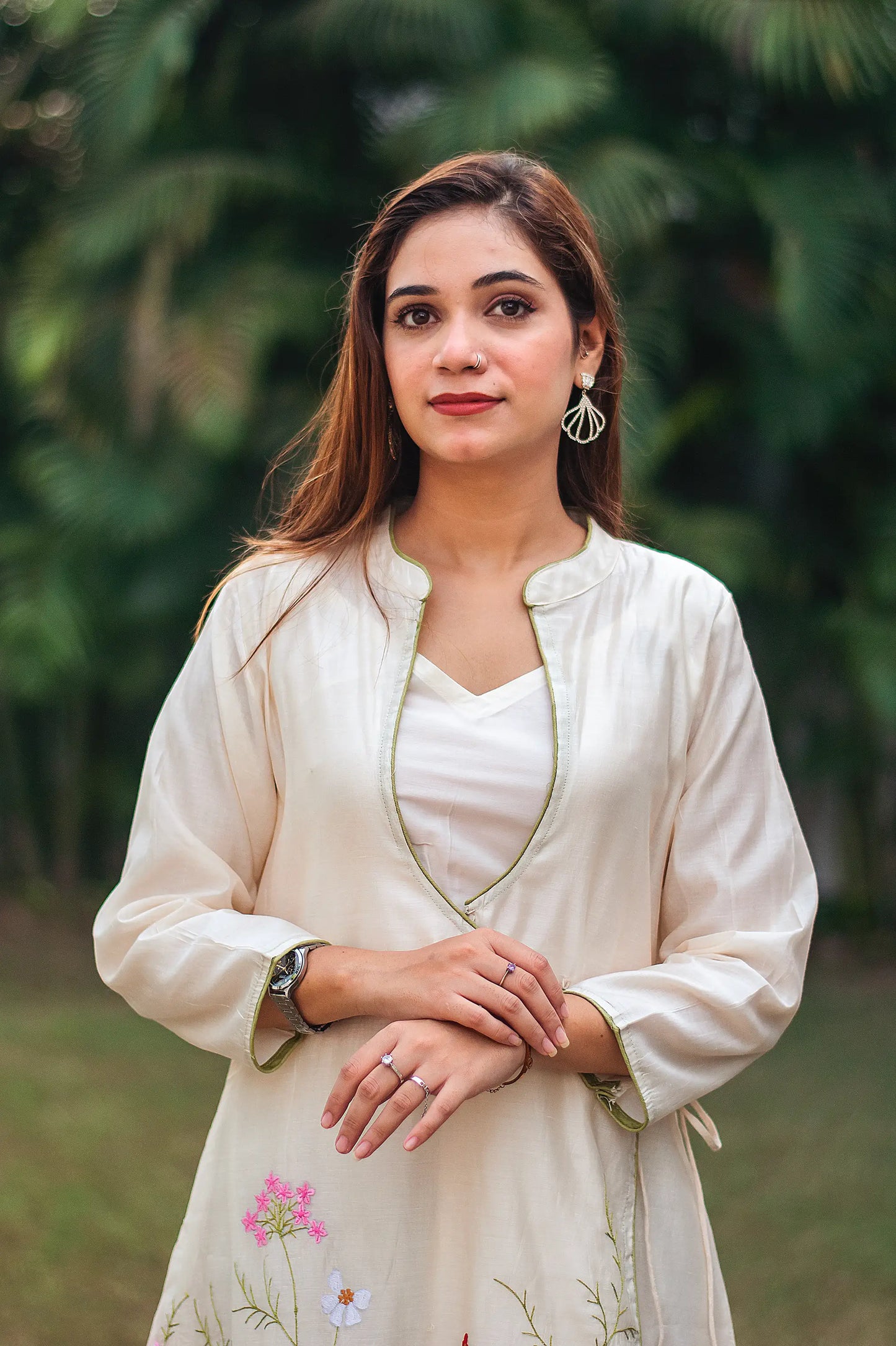 Close-up of an Indian model wearing an off-white angrakha kurta with resham embroidery.