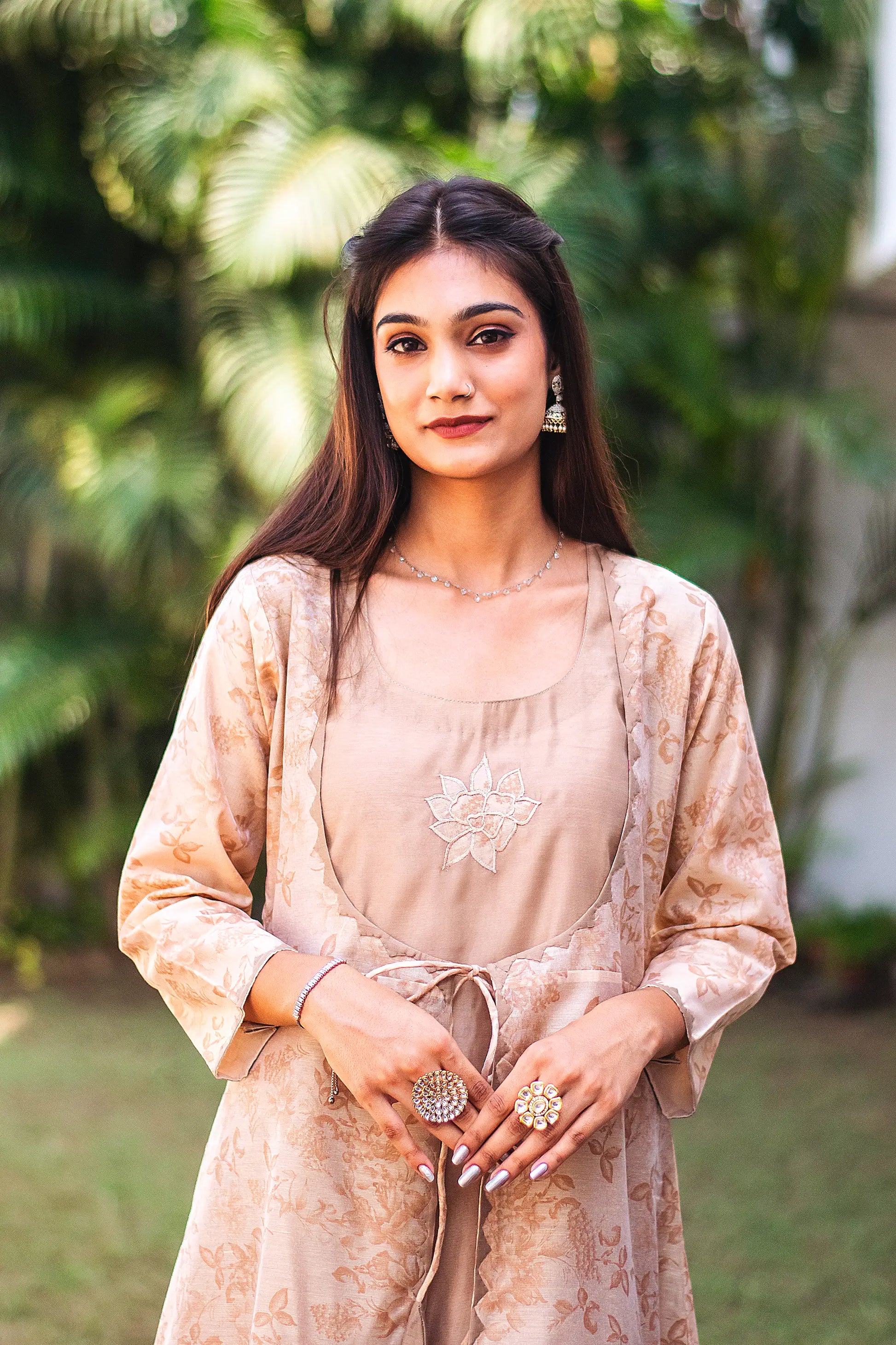 Upper half front view of a model wearing the beige floral print kurta set, featuring a beige floral print chanderi angrakha, matching palazzo