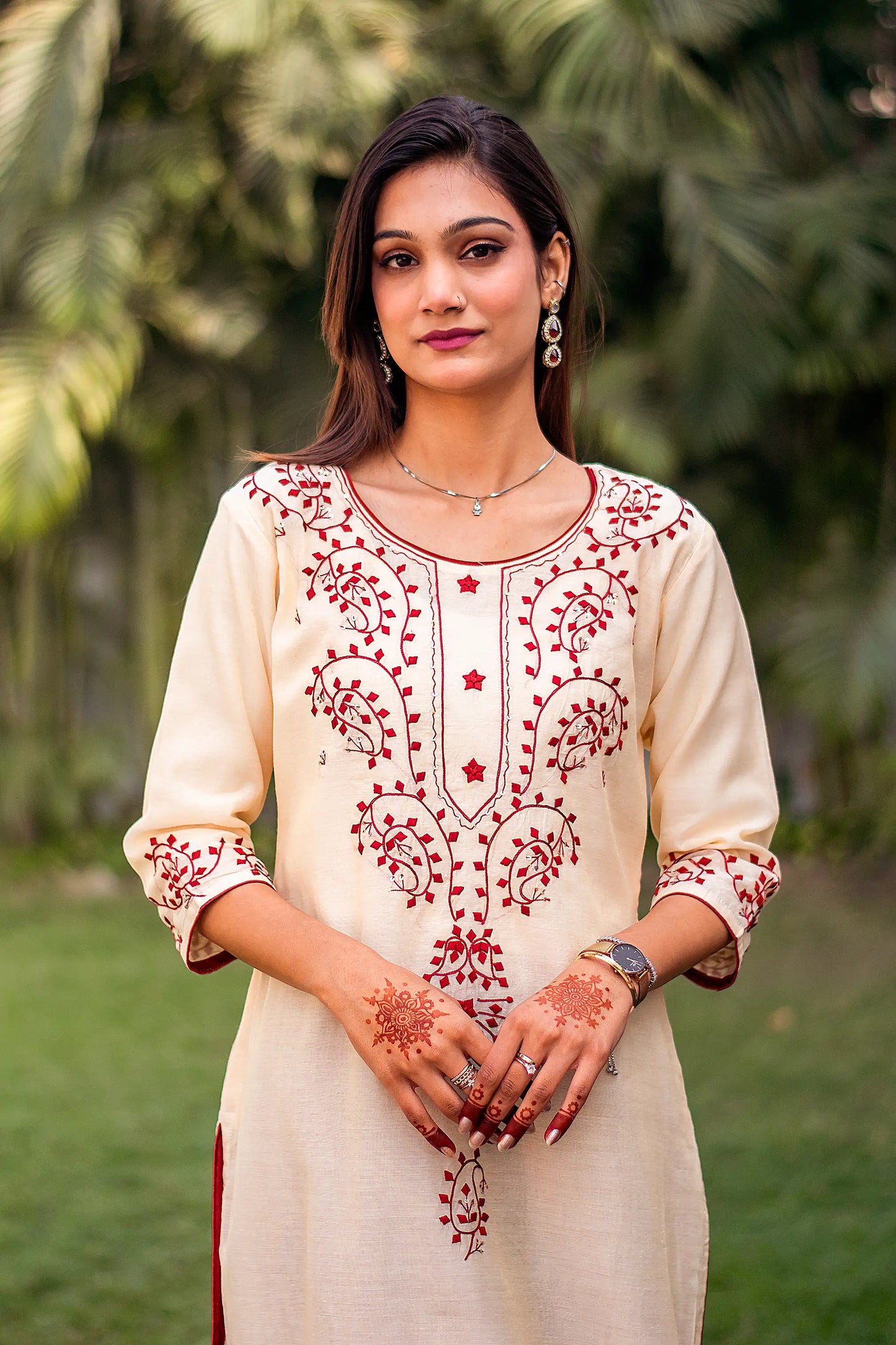 Zoomed-in view highlighting the maroon applique paisley and geometric motifs on the yoke of the beige chanderi kurta.