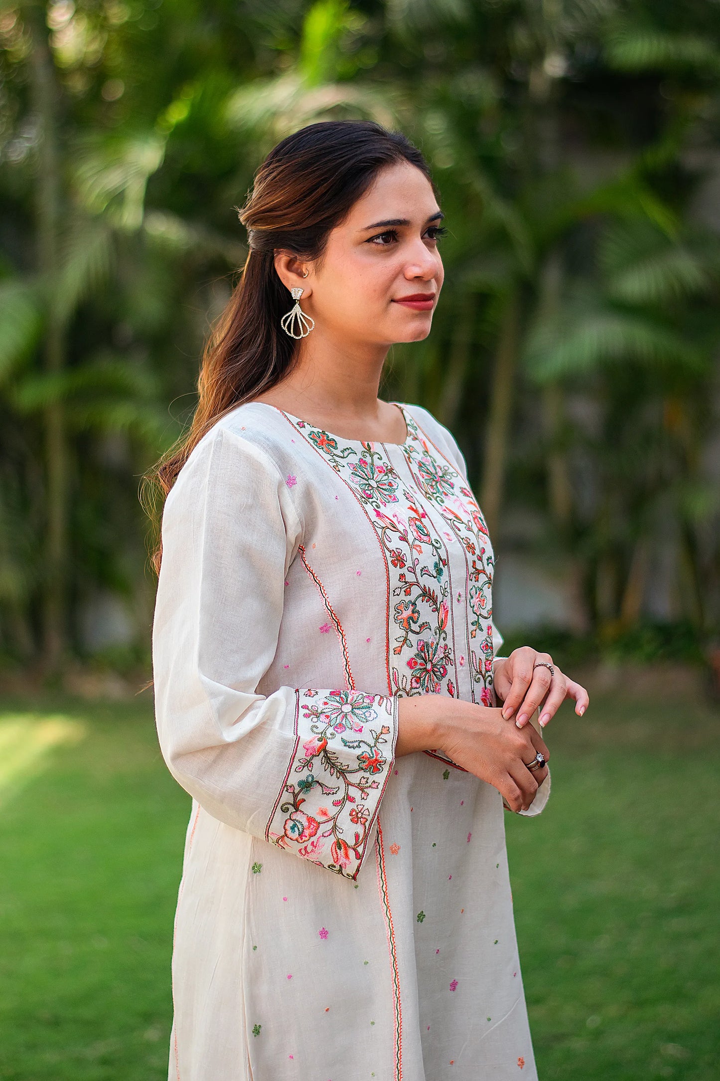 Side view of an Indian model in an off-white kurta with Kashmiri embroidery 