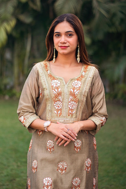 Close-up of the model focusing on the golden gota patti work on the yoke of the beige Chanderi kurta.