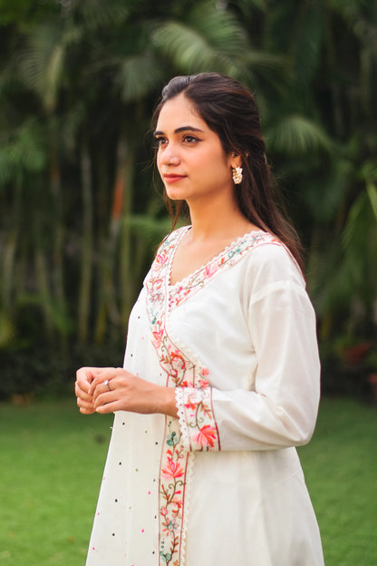 An Indian woman wearing an off-white cotton angarkha with intricate embroidery