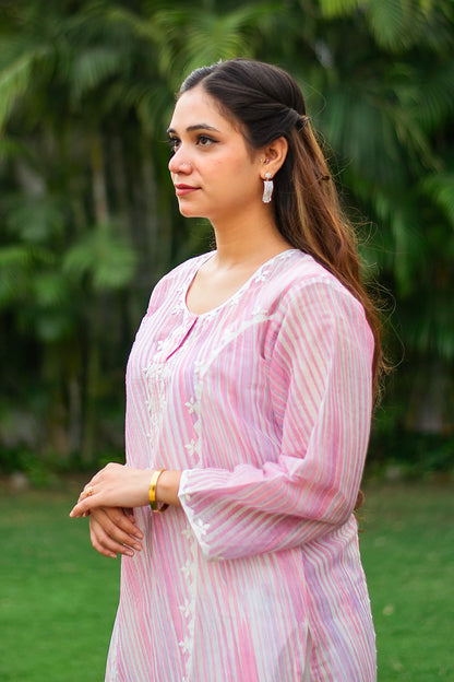 Side view of an Indian model in a pink kurta with applique work.