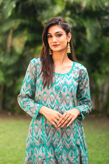 Zoomed-in view highlighting the delicate green applique motifs on the yoke of the grey and green ikat print kurta.